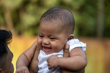 Neşeli bebek havalanırken keyifle gülümser