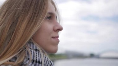 Genç bir kız nehir dolgu üzerinde oturuyor