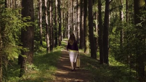 Uma menina caminha pela floresta — Vídeo de Stock