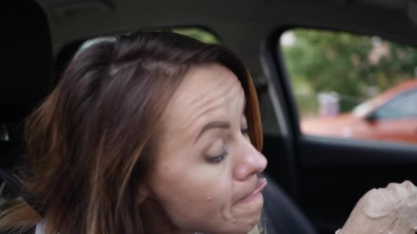 若い女性が車の中でアイスクリームを食べる — ストック動画