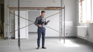 İnşaat sahasında telefonda konuşan işadamı