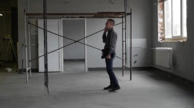 İnşaat sahasında telefonda konuşan işadamı