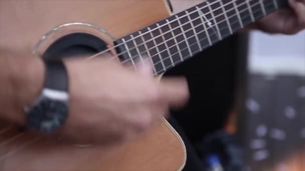 Мужчина играет на акустической гитаре — стоковое видео