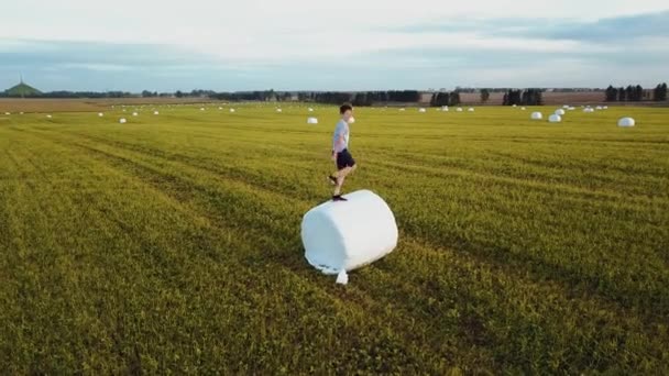 4K Cute Little Boy James And Plays On Row Of Bales — стоковое видео