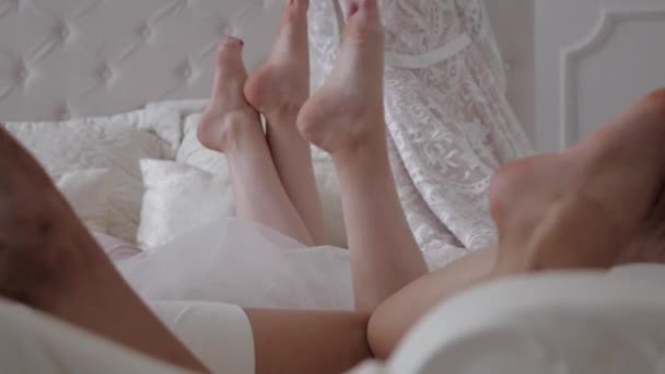 Beautiful bride and her bridesmaid in bathrobes resting, — Stock Video