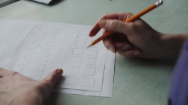 Kadının el ahşap masa üzerinde beyaz kağıda çizim.