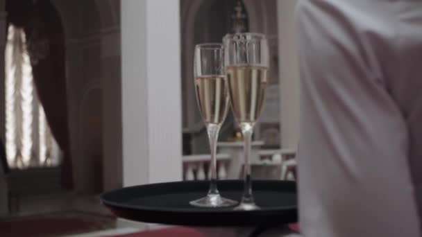 Copos de champanhe em bandeja segurando por garçom pronto para servir em festa . — Vídeo de Stock