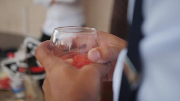Een man die een fruit cocktail in zijn handen houdt — Stockvideo