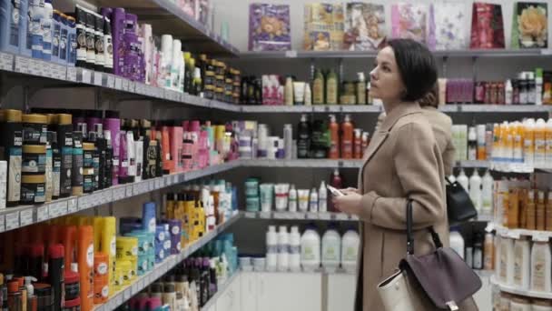 Mulher bonita olhando para cosméticos no supermercado . — Vídeo de Stock
