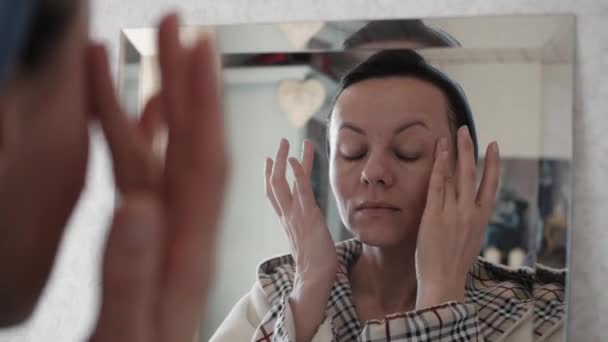 Portré gyönyörű egészséges nő üzembe hidratáló krém arcon. — Stock videók