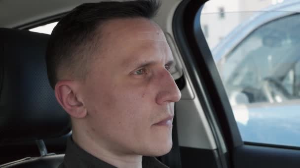 Portret van een man die in een auto zit. Hij schudt zijn hoofd met overtuiging. — Stockvideo