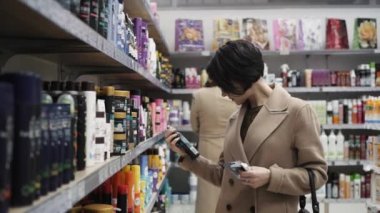 güzel bir kadın kozmetik süpermarkette bakarak.