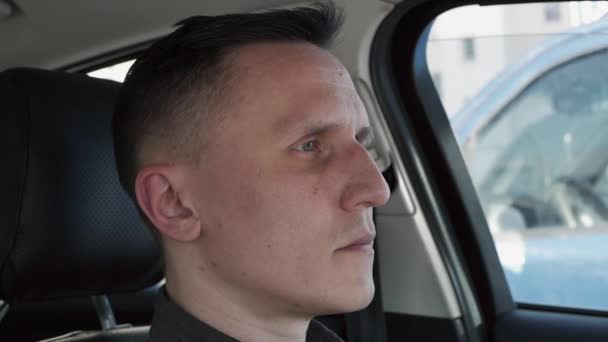 Porträtt av en man sittande i en bil. Han pekar fingret direkt på kameran — Stockvideo