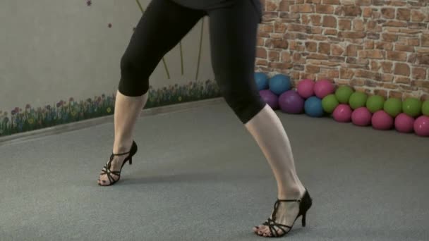 Девушка на каблуках танцует в спортзале — стоковое видео