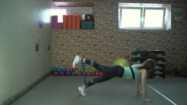 Kız fitness eğitmeni spor salonunda egzersizleri bir dizi gösterir — Stok video