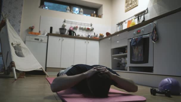 Hombre guapo haciendo ejercicio y haciendo flexiones en la cocina en casa — Vídeo de stock