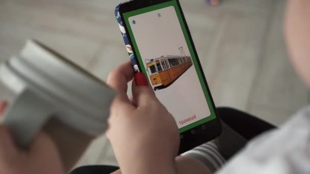 Мама показує її діти картинки на своєму смартфоні і вчить його нові слова — стокове відео