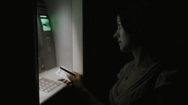 Flicka på natten träder PIN-kod i ATM — Stockvideo