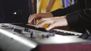 Müzisyen performans sırasında synthesizer çalar.