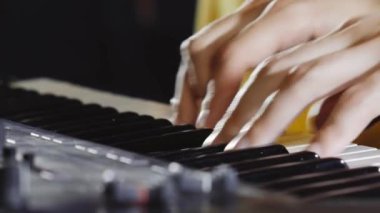 Müzisyen performans sırasında synthesizer çalar.