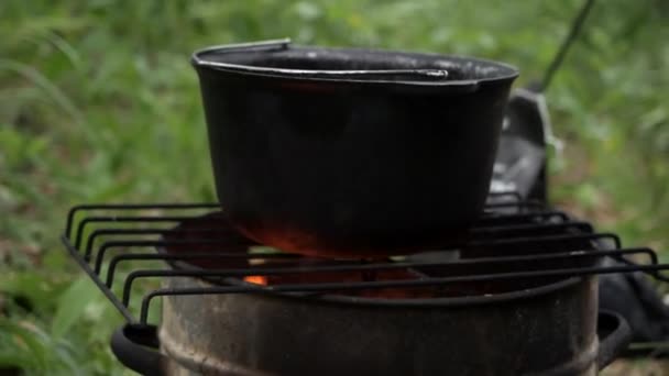 食べ物を準備する火の上の鍋でハイキング旅行で — ストック動画