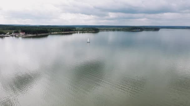 O drone voa lentamente sobre um barco à vela no lago — Vídeo de Stock