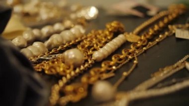 Masanın üzerine birkaç parça mücevher ve kolye serildi..