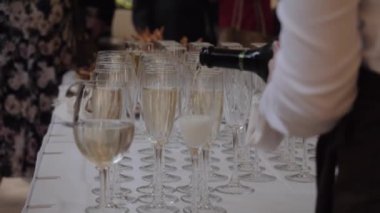 Garson bardağa şampanya doldurur.