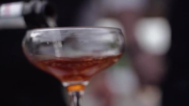 Barmen bardağa alkol doldurur ve kokteyl hazırlar.