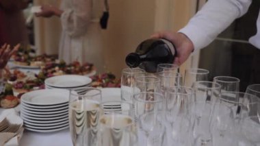 Garson bardağa şampanya doldurur.