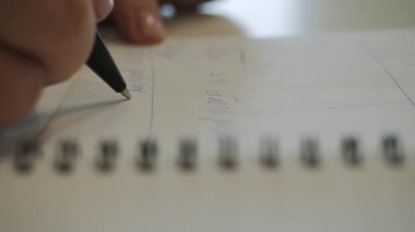 Bir kadının eli not defterine notlar alır..