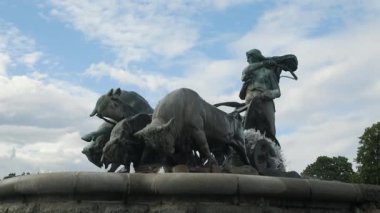 A stunning and striking sculpture that portrays a hunter alongside wildlife, beautifully set against a cloudy sky