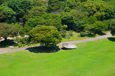 Gezegen binası, Yeomiji Botanik Bahçesi 'nin yakınlarındaki bir ağaç denizinin üzerinde görünür. Açısal beton yapısı ve kırmızı çatısı Seogwipo' nun yoğun yeşil gölgesiyle çelişir..
