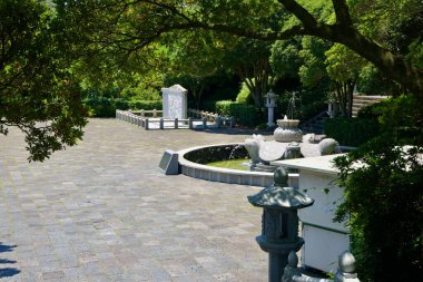 Taş kaplumbağa fıskiyesi ve mermer çeliği, Jungmun Turizm Kompleksi 'ndeki Cheonjeyeon Şelalesi' nin yakınlarındaki gölgeli bir meydanda, fener direkleri ve ağaçlarla kaplı bir meydanda oturuyor..