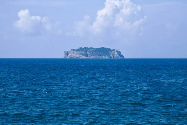 Beomseom Adası Seogwipo 'nun derin mavi sularından yükseliyor. Kayalıkları ve alçak ormanı güney ufkunda dalgalanan yaz bulutlarının altında düz bir profil oluşturuyor..