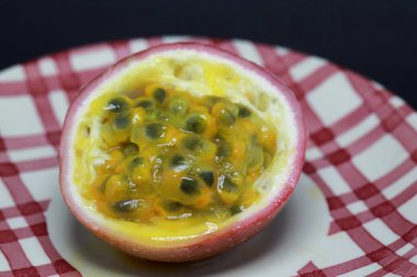 Tutku meyvesinin sulu içeriğini gösteren izole edilmiş makro pozu. Meyve bir pepo, oval, yuvarlak yuvarlak veya koyu mor, olgunluk, yumuşak sert, sulu bir iç ile sayısız tohum ile dolu. 