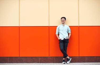 Çekici çocuk gülümseyen üzerinde bir turuncu duvar