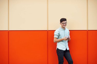 Güleryüzlü ve cep telefonuyla sokakta genç çekici adam.