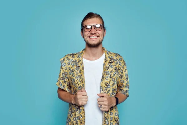 Retrato de hombre hipster guapo con gafas, vestido con ropa elegante, riéndose de la cámara, aislado sobre fondo amarillo . —  Fotos de Stock