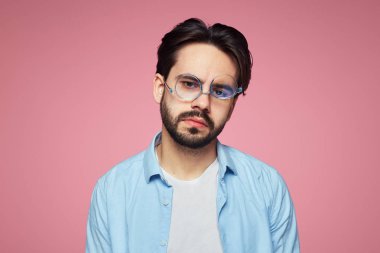 Sıkılmış ifade bıkmış şık traşsız adam, uzun bir zor iş gününden sonra yorgun, pembe arka plan üzerinde izole