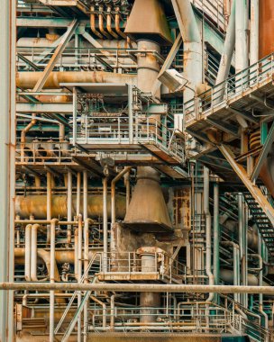 Industrial pipes rusty machinery abstract structure poster texture. Detailed close-up of an old, complex network of industrial pipes, valves and rust-covered metal surfaces. Grungy metallic construction full of mechanical elements, platforms and ladd