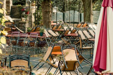 Closed restaurant terrace chairs empty crisis shutdown. Outdoor dining area with overturned chairs symbolizing economic collapse business closure seasonal decline financial hardship deserted patio scene autumn atmosphere