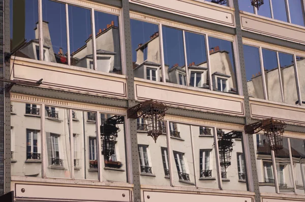 Facade of buildings in Paris with the reflection of other buildings in the windows