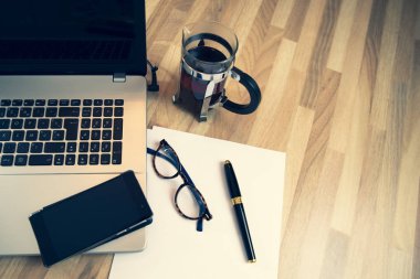 Dizüstü bilgisayar bir bardak çay, bir kalem, bir masada bırakır ve gözlük