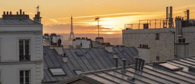 Eyfel Kulesi ve Paris Montmartre bir gün batımı ile görülen çatılarına