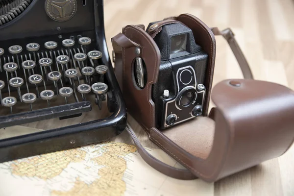 Detail of the keys of an old typewriter, with an old camera and a map