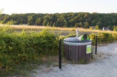 Garbage bins in the countryside at the edge of a field clipart