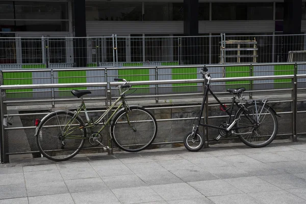Two bicycles parked against a gate in town