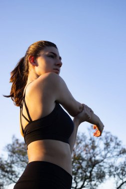 Adolescent exercising outdoors, fitness training and healthy living concept.Young woman practicing sports. Perfect for wellness advertisements and outdoor sports campaigns.Vertical real picture
