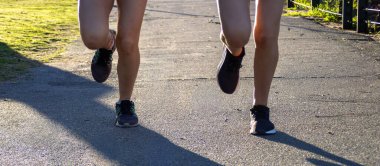 Close-up image of two teenager training outdoors.Fitness and wellness lifestyle. Horizontal real picture with space for text. Especially for sports campaigns, healthy outdoor living. 